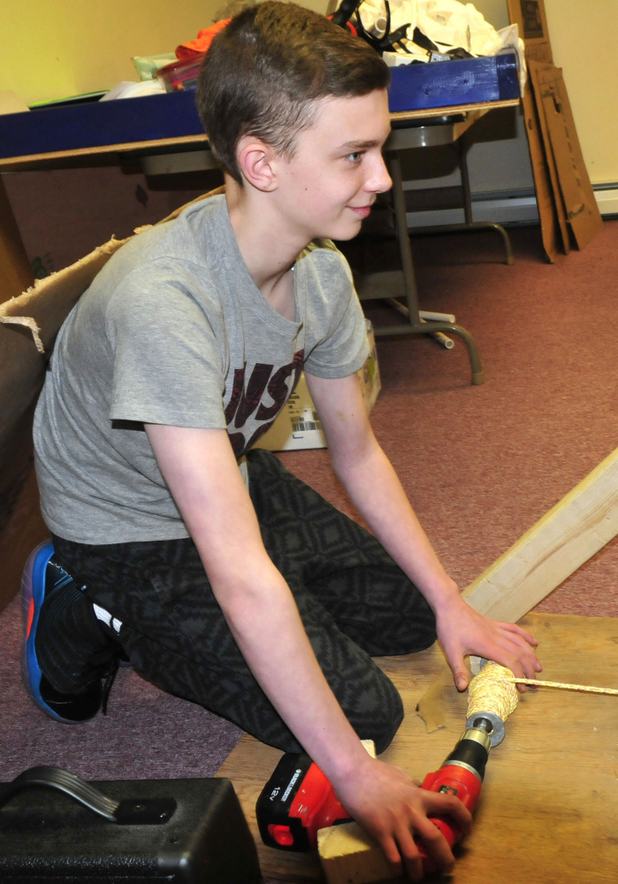 Isaiah Simoneau uses a power drill and ropes to pull a vehicle toward him as he and members of the Somerset Homeschool Co-op demonstrate their team Infinite Velocity entry that earned them a state championship in an academic challenge competition Wednesday. They will compete for a national title in Tennessee.