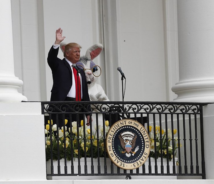 President Trump accompanied by the Eastern bunny, waves from the Truman Balcony of the White House.