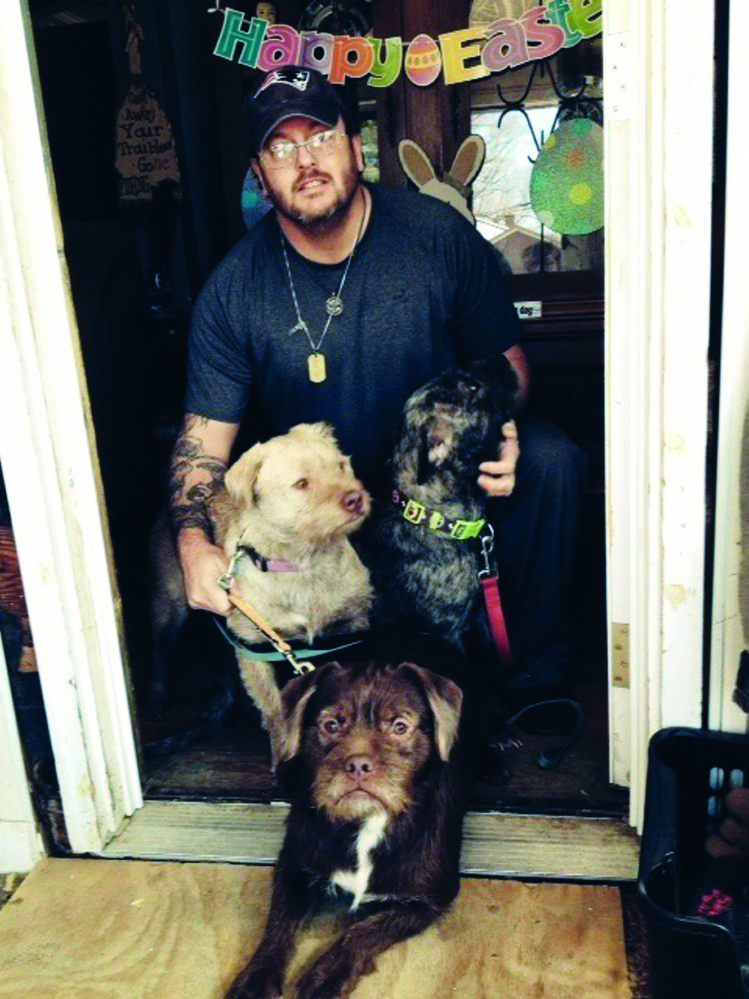 Paul Mann Sr. and three dogs — Flower, Brownie and Sofia — are seen at his Western Avenue home in Waterville on Friday.