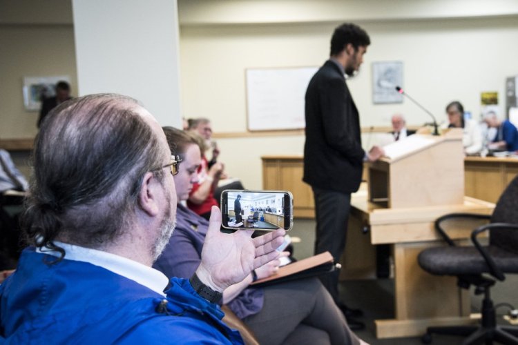 Todd Tolhurst, left, of China, president of Gun Owners of Maine, uses his phone to record the testimony of Shaman Kirkland, right, a student at the University of Southern Maine, during a hearing on a bill to allow students to carry concealed guns on college campuses. Kirkland expressed his strong objection to the proposed legislation, while Tolhurst supported it.