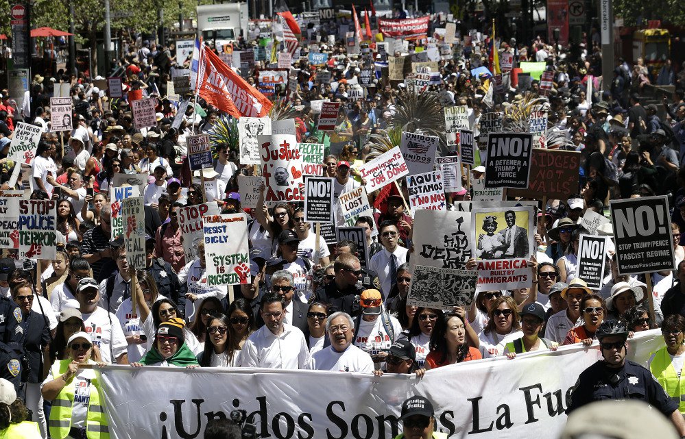 San Francisco Mayor Ed Lee, bottom center, walks with protesters on Market Street during a march in San Francisco on Monday. Immigrant groups and their allies joined forces to carry out marches, rallies and protests in cities nationwide to mark May Day.