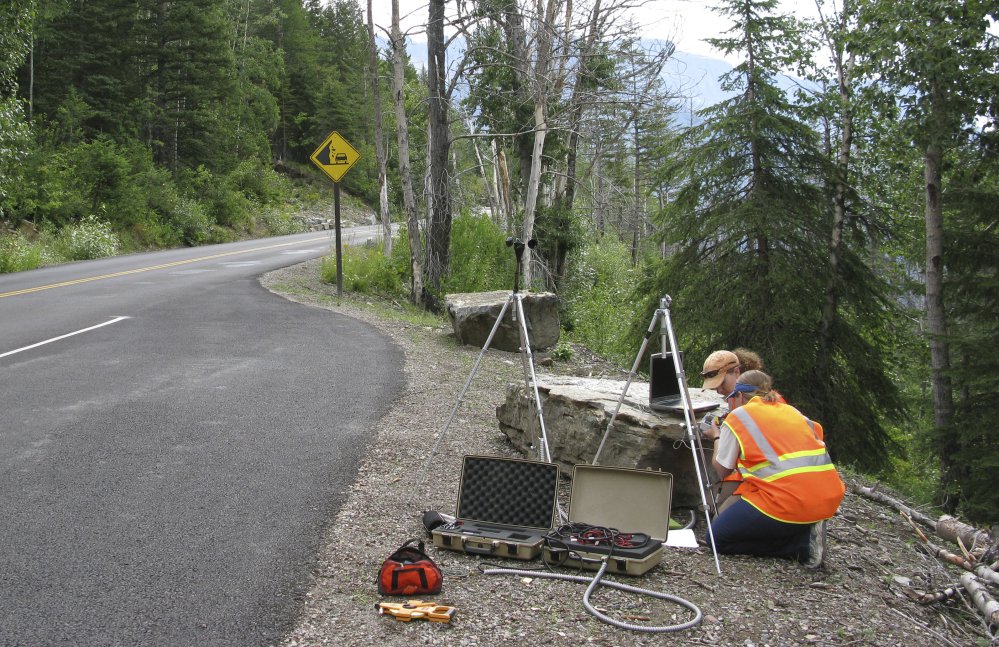 In this photo provided by the National Park Service a National Park Service staffer sets up an acoustic recording station on Going-to-the-Sun Road to capture the impact of traffic on acoustic conditions in Glacier National Park, Mont. The call of the wild is getting harder to hear. Peaceful natural sounds, bird songs, rushing rivers and rustling grass, are being drowned out by human-made noise in nearly two-thirds of America's protected parks, forests and wilderness areas, a new study finds. (National Park Service via AP)