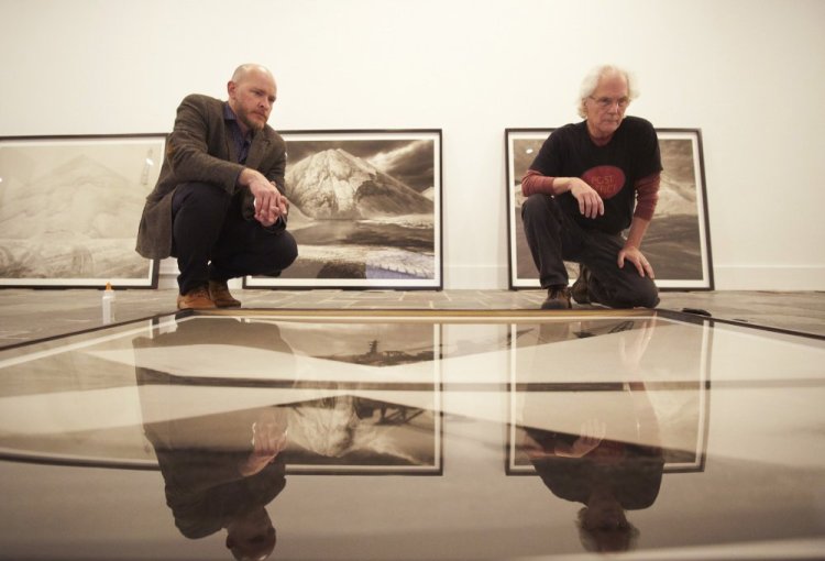 Michael Mansfield, left, the new executive director and chief curator at the Ogunquit Museum of American Art, examines a photograph with Carl Austin Hyatt in preparation for "Salt/Sea/Stone," an exhibition of Hyatt's large-scale images.