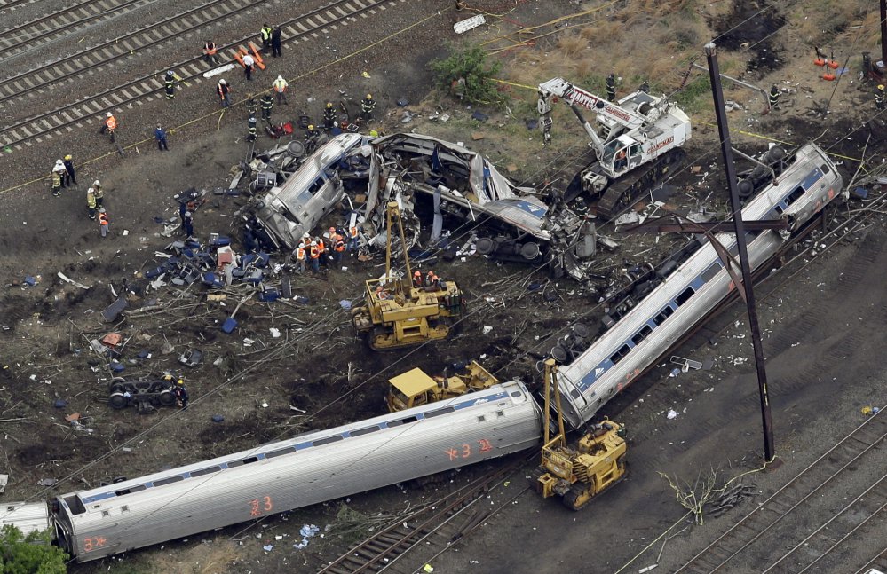 Emergency personnel work near the wreckage of the Amtrak train that derailed in Philadelphia while taking a a 50 mph curve at 106 mph on May 12, 2015. Eight people and about 200 were injured.