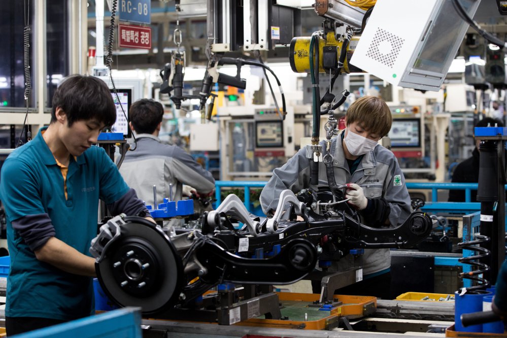 Employees assemble vehicle chassis modules on a production line at the Hyundai Mobis Co. factory in Asan, South Korea. Some South Korean companies are requiring workers to address each other by English names, and it's an uncomfortable change for many.