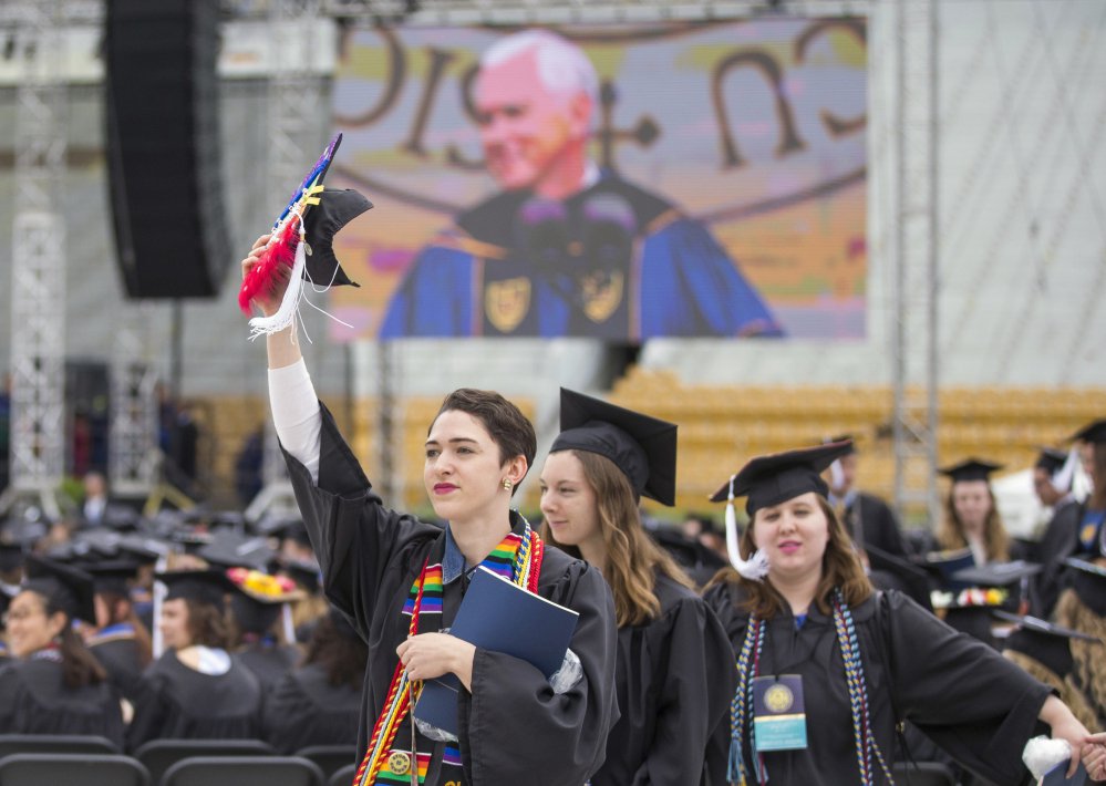 Notre Dame graduates walk out of Notre Dame Stadium in protest as Vice President Mike Pence speaks during the 2017 commencement ceremony Sunday in South Bend, Ind.