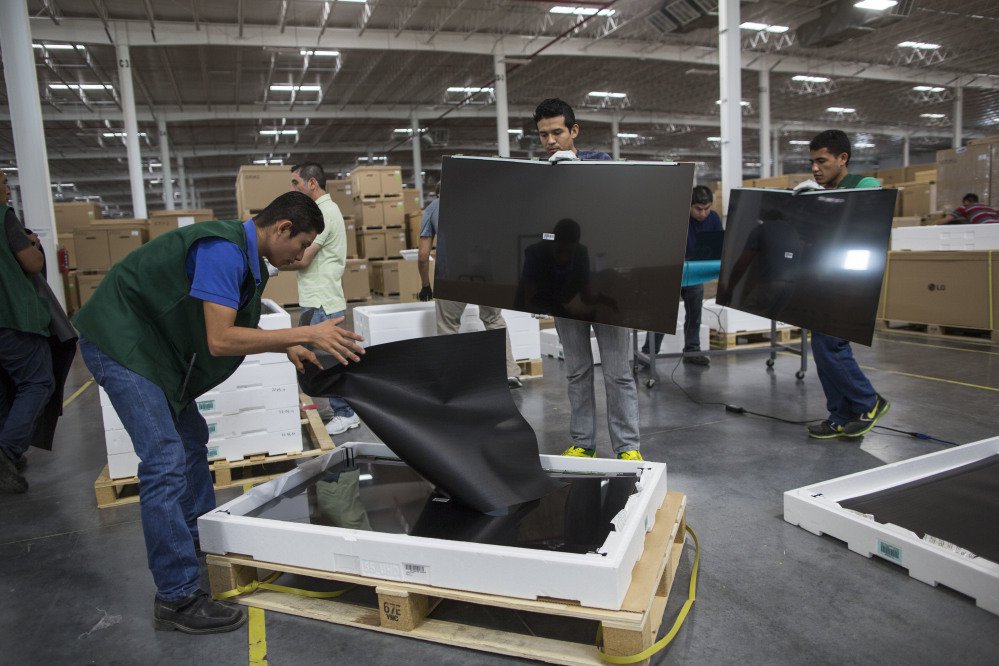 Workers check flat-screen screens for faults at Pantos logistics, an assembly plant in Reynosa, Mexico. Many of the workers make only $50 to $60 for a six-day work week and rely on a few hours of daily overtime to make ends meet.
