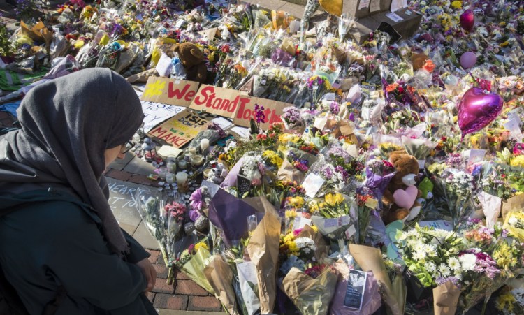 A woman looks at the floral tributes and messages left for the victims of the concert blast, during a vigil at St Ann's Square in central Manchester, England, on Wednesday.