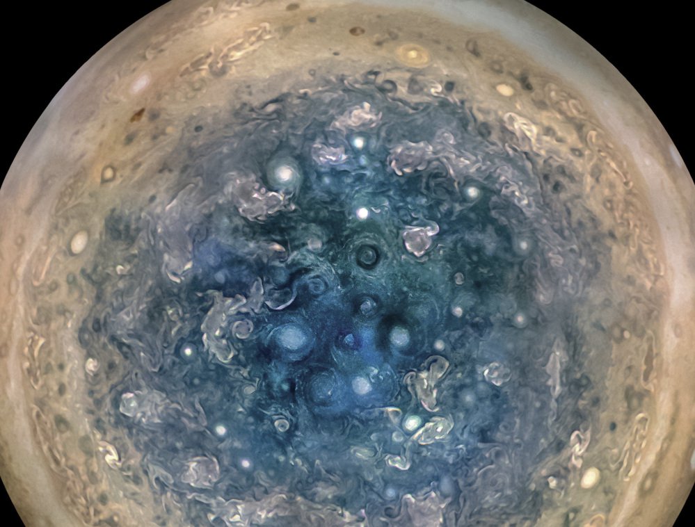 This image made available by NASA on Thursday, May 25, 2017, and made from data captured by the Juno spacecraft shows Jupiter's south pole. The oval features are cyclones, up to 600 miles (1,000 kilometers) in diameter. The cyclones are separate from Jupiter's trademark Great Red Spot, a raging hurricane-like storm south of the equator. The composite, enhanced color image was made from data on three separate orbits. (NASA/JPL-Caltech/SwRI/MSSS/Betsy Asher Hall/Gervasio Robles via AP)