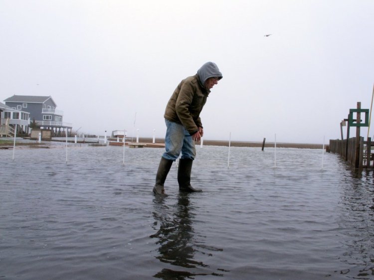 Jim O'Neill walks through a flooded street in front of his home in Manahawkin N.J., after a moderate storm in April. He lives in a low-lying area near the Jersey shore, and is often affected by back-bay flooding, a type of recurring nuisance flooding that's affecting millions of Americans.