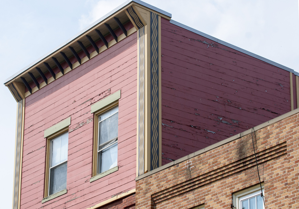 Staff photo by Joe Phelan
The upper floors of Monkitree Gallery, left, and Brunswick Trading buildings that were part of the facade grant program are seen Friday on Water Street in Gardiner. The owners plan to paint the fourth floor of Monkitree and repair the roof of Brunswick Trading because it drains down the front of the building as evidenced by the dark stain over the window.