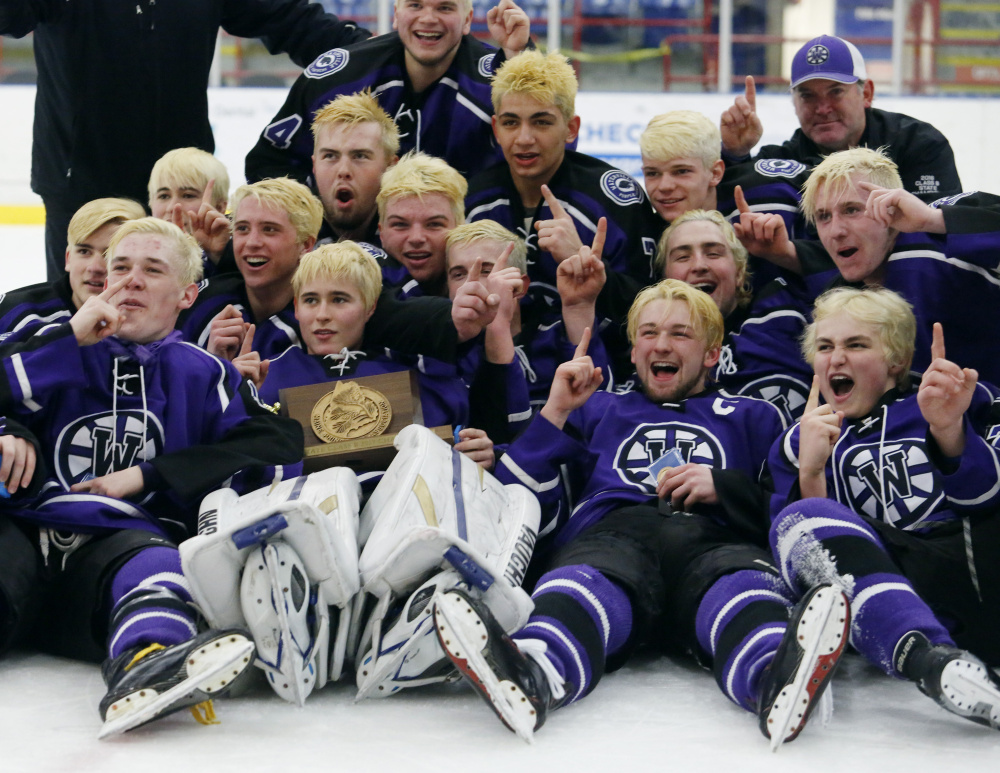 The Waterville hockey team celebrates after winning the Class B state championship in Lewiston this past season.