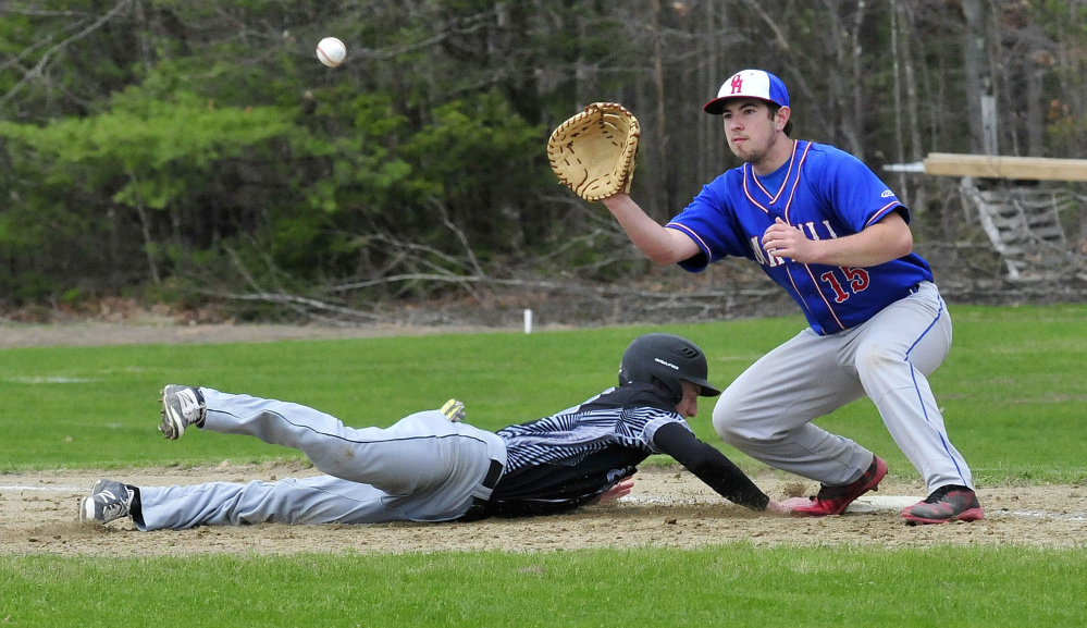 Bridgeway's Evan Bess makes it back to first base as Oak Hill's Reid Cote fields the throw Wednesday in North Anson.