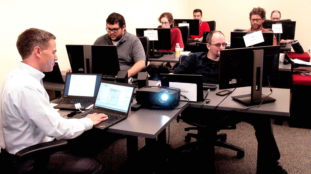 Collaborative Consulting trainer Tristan Lewis assists employees learning one of the systems at the company on Aug. 29, 2016, in the Hathaway Creative Center in Waterville. CGI Group bought the company in November 2016 and will be represented at the Central Maine Growth Council's job fair Friday morning.