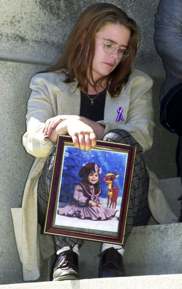 Christy Darling (then Christy Baker) holds a photo of her daughter Logan Marr, who died in foster care in 2001. Logan's killer was released from prison last month and Logan's sister, Bailey Charest, recently obtained money from the state to help pay for her college expenses.