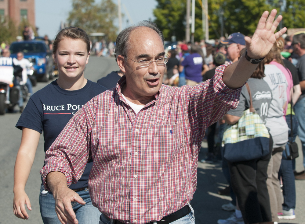 Bruce Poliquin marches with his campaign workers, waving and shaking hands, along a parade route in October 2014 at Riverfest in Old Town.