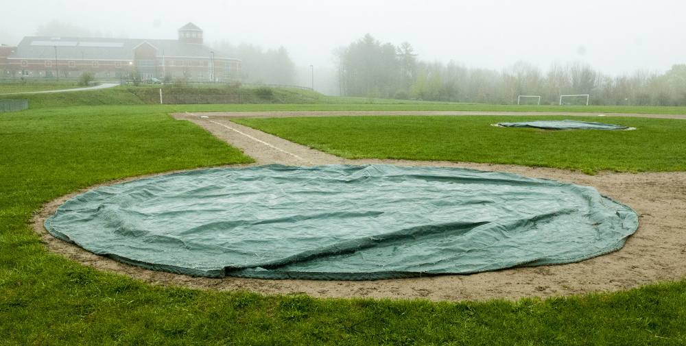 Tarps cover home plate and the pitcher's mound at Winthrop High School.