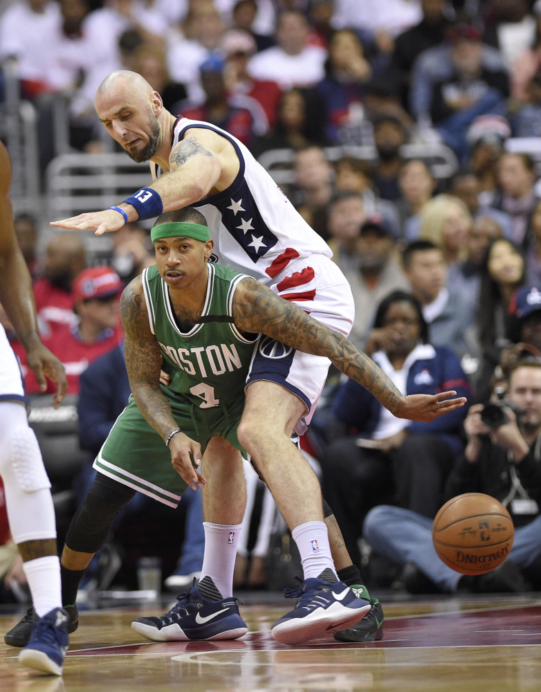 Boston Celtics guard Isaiah Thomas (4) passes the ball as Wizards center Marcin Gortat defends during Game 4 on Sunday night.