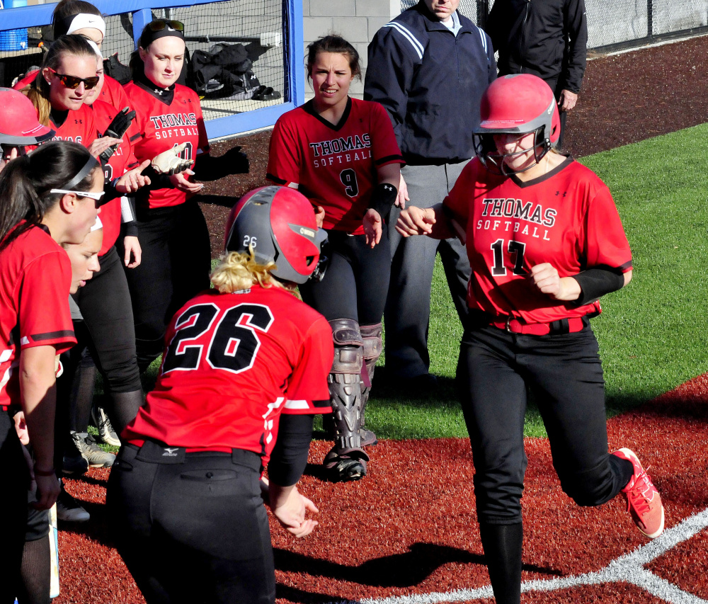 Thomas first baseman Korrie Laren touches home plate as teammates surround her after she hit a home run against Colby earlier this season in Waterville.