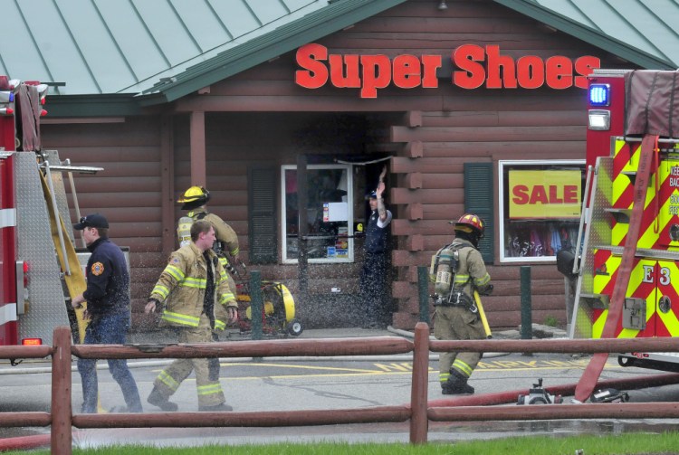 Waterville and Oakland firefighters responded to a report of a fire Tuesday at the Super Shoes store in Waterville. Smoke came out from a side entrance as firefighters carried out smoldering footwear.