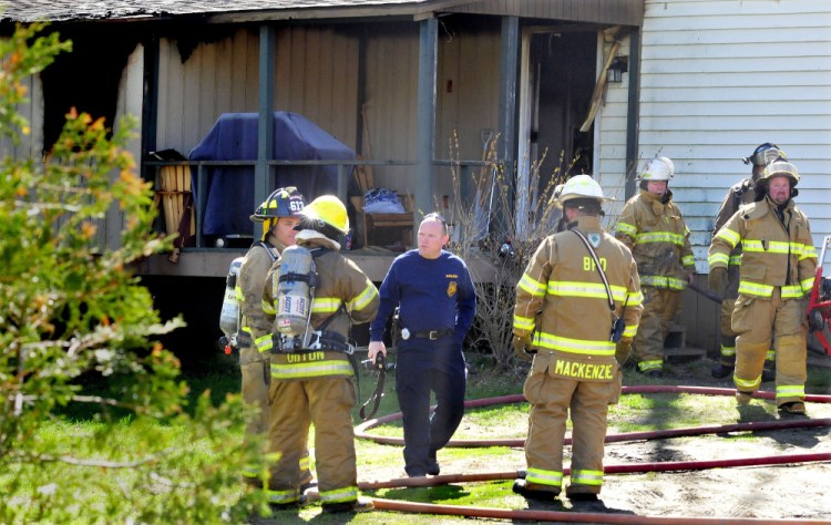 Jeremy Damren, center, of Office of State Fire Marshal, speaks with firefighters Wednesday while investigating a fire that destroyed a mobile home that morning on Smithfield Road in Belgrade.
