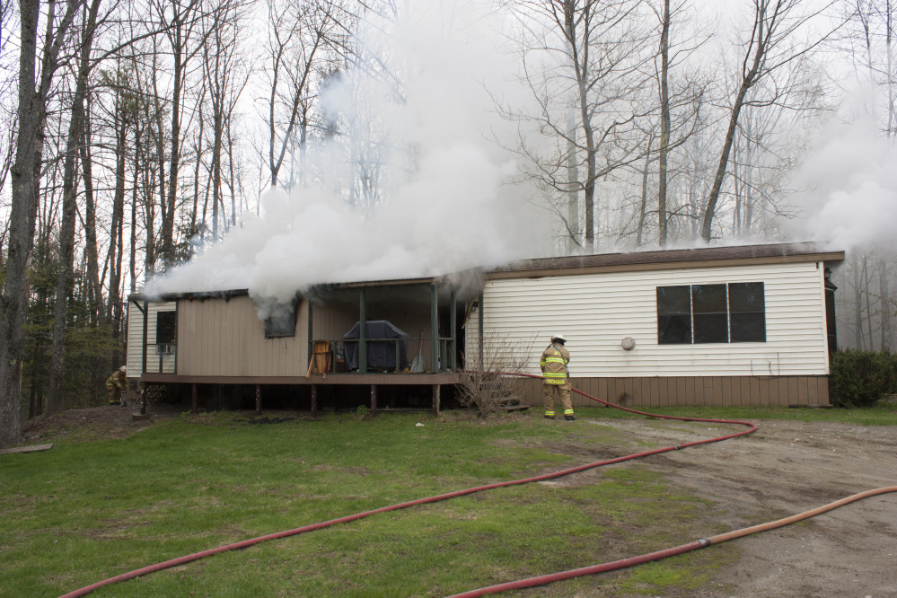 Smoke billows on Wednesday from the mobile home at 905 Smithfield Road in Belgrade.