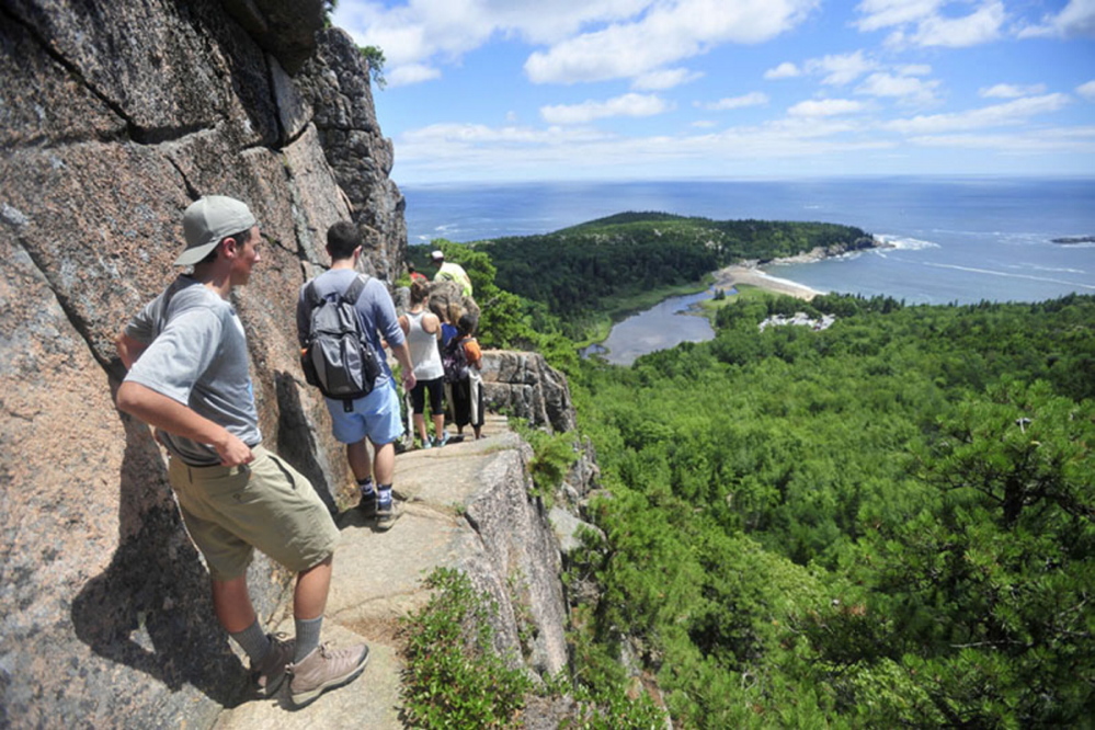 A line of hikers files up the Beehive Trail in 2015 near Sand Beach at Acadia National Park in Bar Harbor.