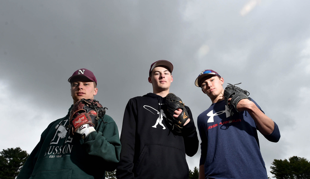 Nokomis pitchers Cody Rice, left, Matthew Dyer, center, and Joshua Perry stand on their mound during practice Thursday.