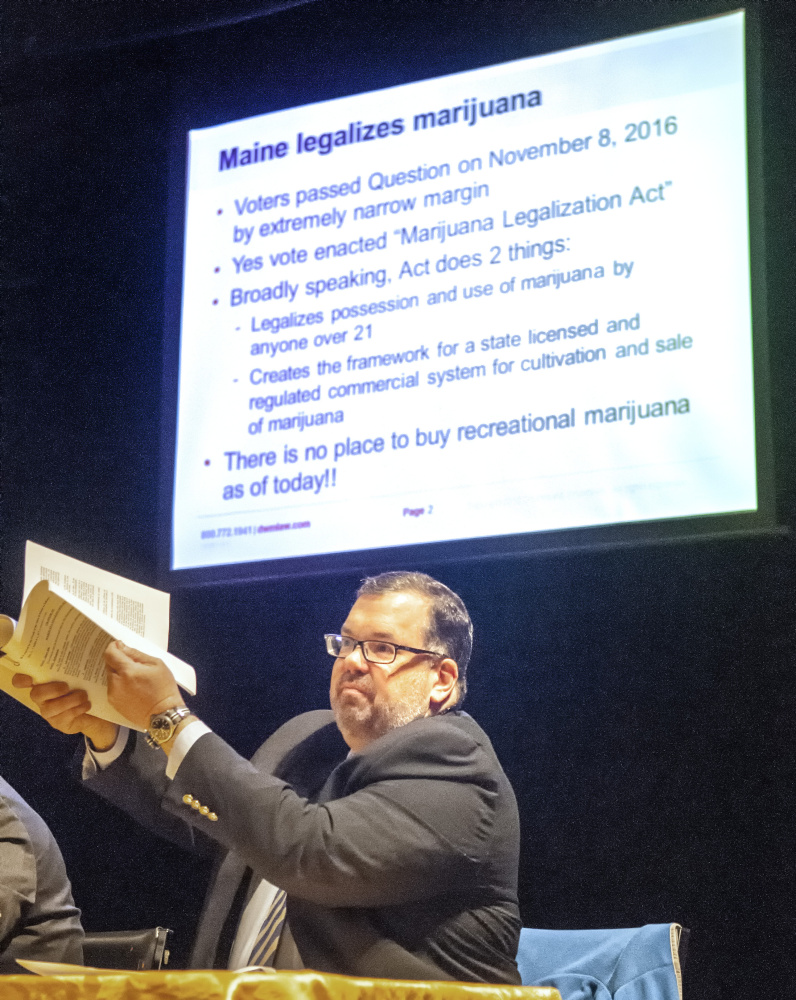 Ted Kelleher, an attorney with Drummond Woodsum, holds up the 30 page Marijuana Legalization Act referendum, that passed last fall, on Friday during the "Marijuana on Main Street" event sponsored by Maine Downtown Center in Johnson Hall in Gardiner.