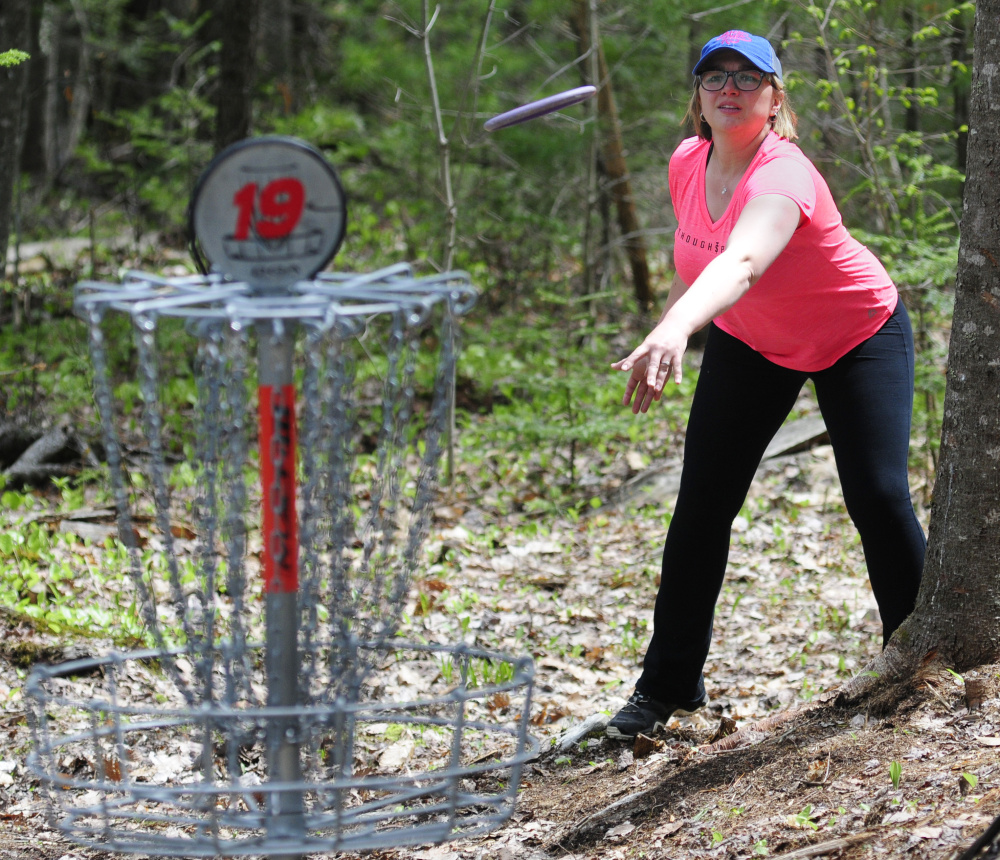 Staff photo by Joe Phelan 
 Megan Norton throws her disc toward the basket on Saturday during the Farmers Daughters Open at CR Farm Disc Golf in West Gardiner.