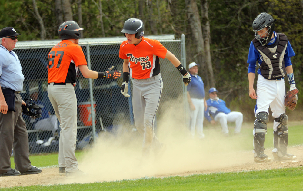 Photo by Jeff Pouland 
 Gardiner Area High School's Alic Shorey gets congratulated by Nick Pooler, left, after scoring a run during Saturday's game against Erskine Academy in South China.