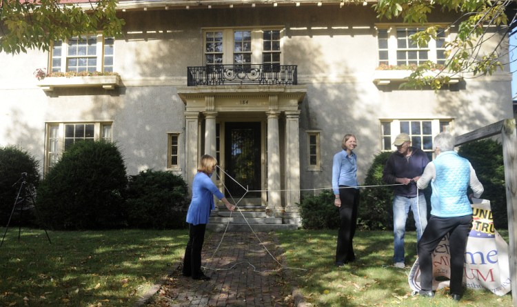 Genie Gannett, left, unknots a rope that Rebecca Lazure, second from left, Denis Thoet and Susan Gross used to hang a sign for the First Amendment Museum in front of the Gannett House in Augusta in this October 3 file photo. Gannett serves as chairwoman and president of the board; Lazure serves as executive director and Gross and Thoet are on the board.