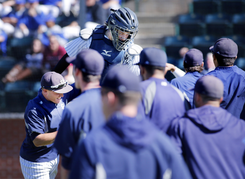 Kip Richard is met by University of Southern Maine teammates after they beat Eastern Connecticut State on Friday.