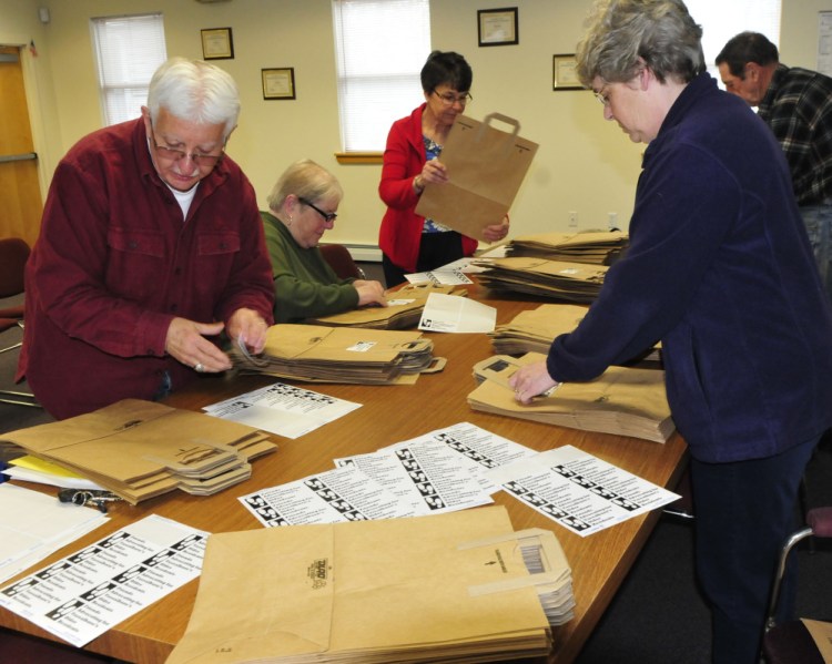 On Monday members of Vassalboro's FAVOR committee, Friends Advocating for Vassalboro's Older Residents, including Jim Schad and Town Manager Mary Sabins, put stickers on bags for the Services for Seniors fair at the town office on May 25.