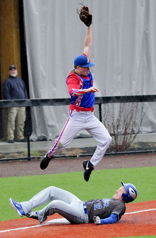 Lawrence baserunner Brandon Hill makes it to third base as Messalonskee's Cam Goff goes airborne to haul in a ball during a game Monday at Colby College.