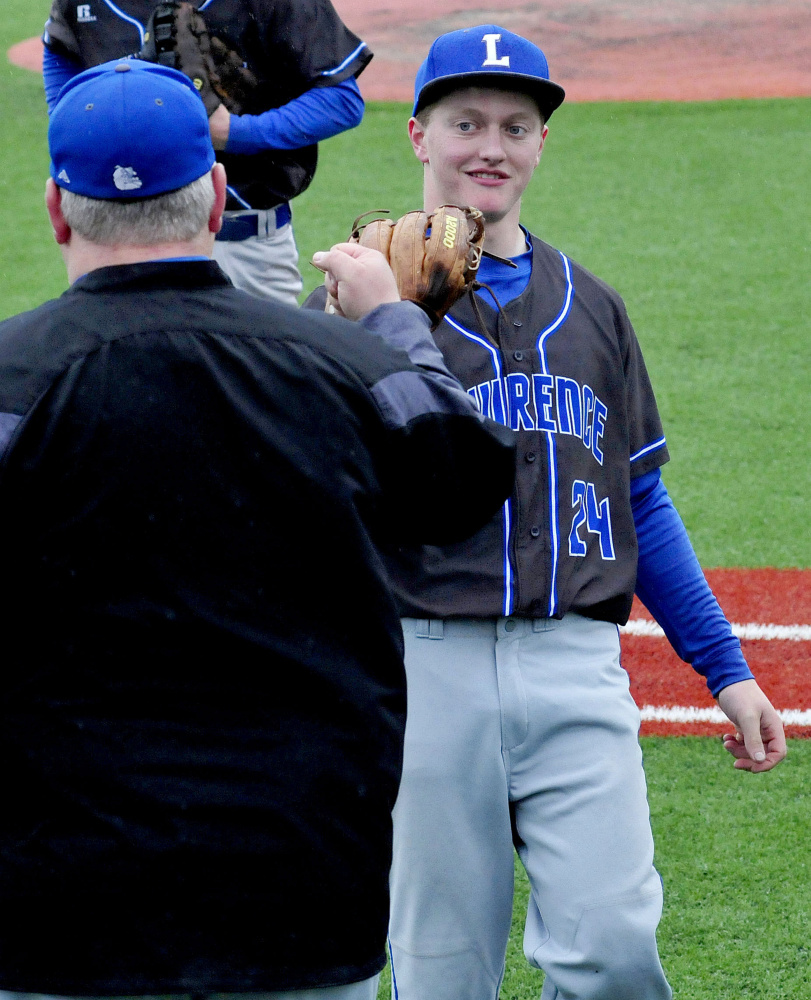 Lawrence baseball coach Rusty Mercier congratulates pitcher Riley Parlin after a good inning against Messalonskee on Monday.