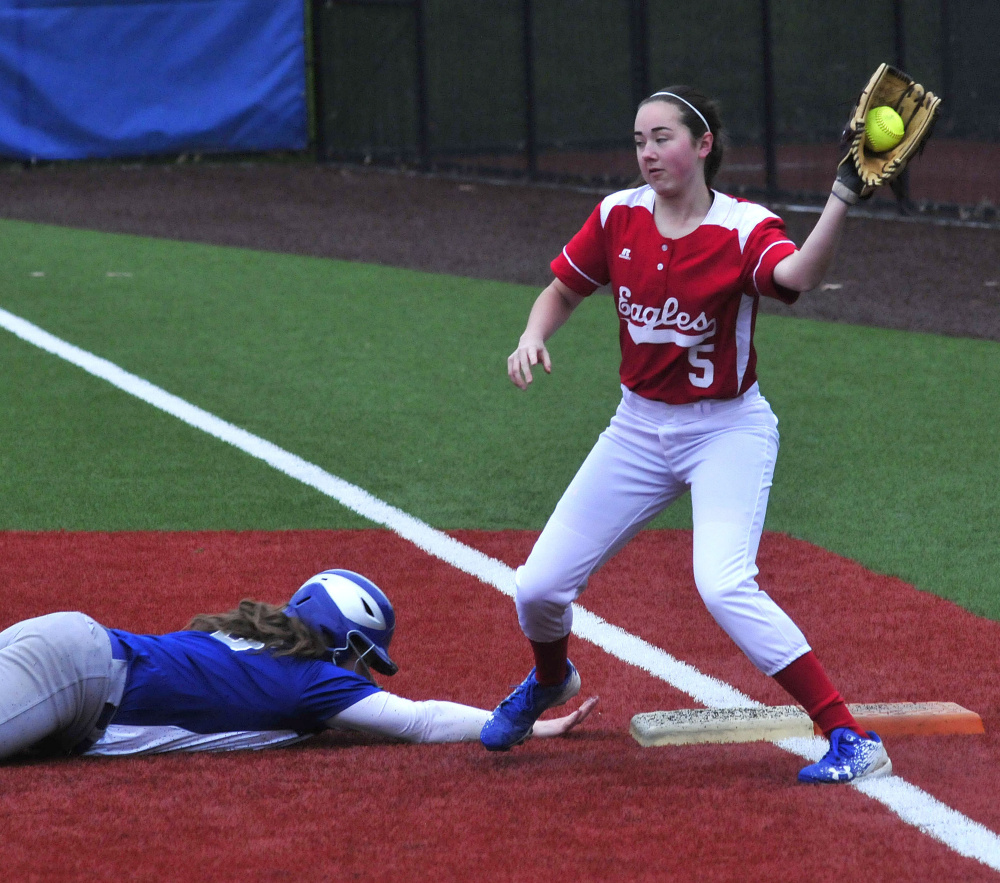 Lawrence runner Haley Holt slides safely back into first base as Messalonskee's Alyssa Genness takes the throw during a Kennebec Valley Athletic Conference Class A game Monday at Colby College in Waterville.