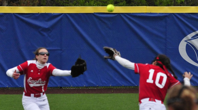 Messalonskee's Danielle Holt, left, and Kate Pino run to catch a fly ball during a Kennebec Valley Athletic Conference Class A game against Lawrence on Monday at Colby College in Waterville.
