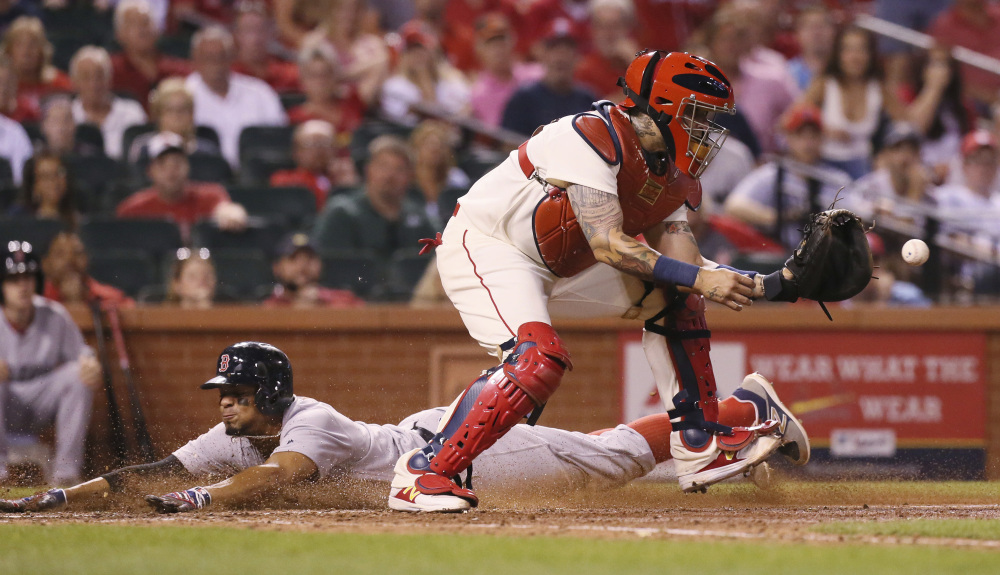Boston Red Sox shortstop Xander Bogaerts scores past St. Louis Cardinals catcher Yadier Molina on a sacrifice fly during the eighth inning Tuesday.