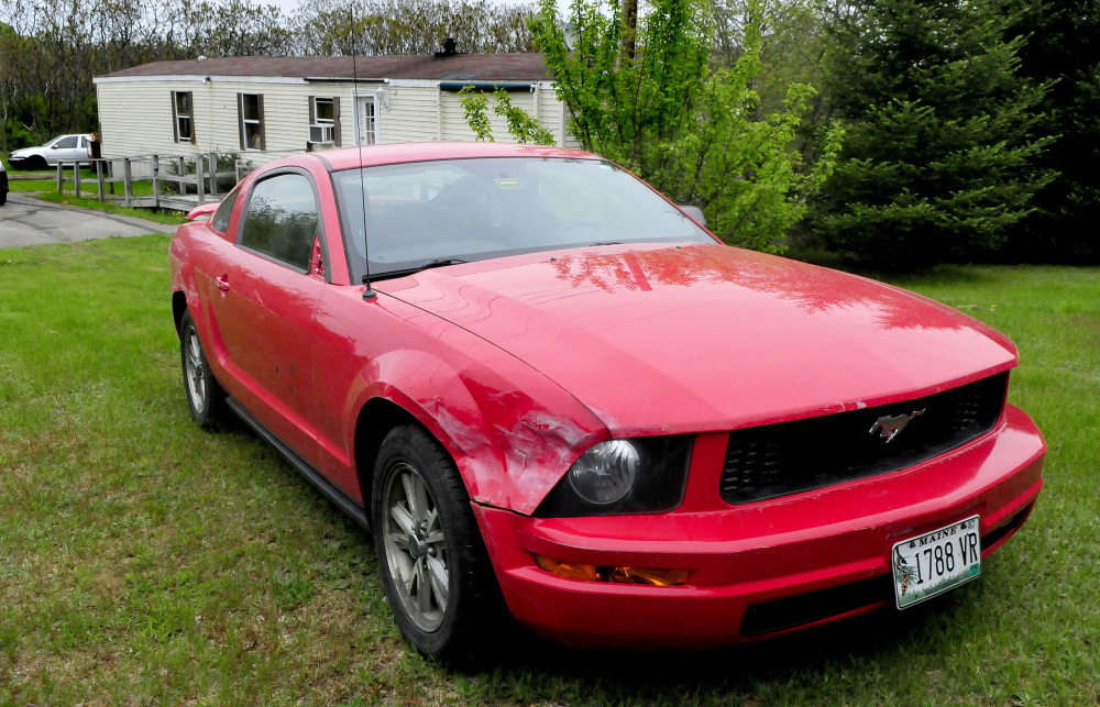 This Mustang vehicle is damaged on the front passenger side near skid marks on the driveway and lawn at 1003 Oakland Road in Belgrade on Monday. Homeowner Roger Bubar died in a police officer-related shooting over the weekend and his son, Scott Bubar, was wounded. A neighbor said the younger Bubar was spinning the tires on the car, doing burnouts and at one point crashed it into the mobile home, prior to the shooting.