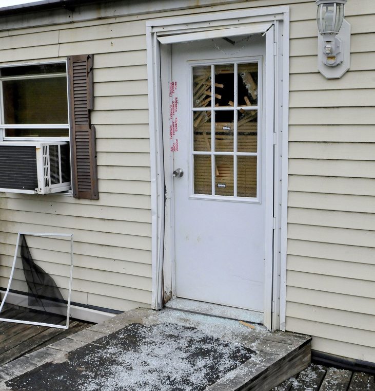 Glass from a shattered window in a door that is sealed with police evidence tape is seen at the front entrance to a mobile home at 1003 Oakland Road in Belgrade on Monday. Homeowner Roger Bubar died in a police officer-involved shooting on May 20 and his son Scott Bubar was wounded.