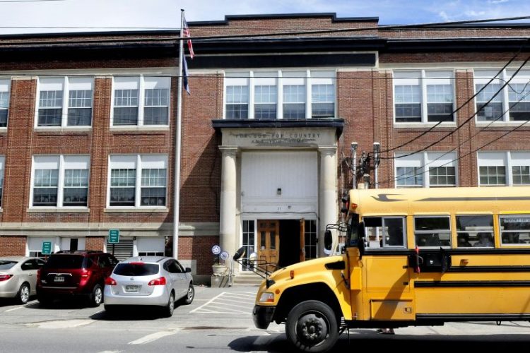 Students board a school bus parked in front of the Albert Hall School in Waterville on May 23. Some residents are calling for the closure of the school as soon as possible to save money amid a declining student population, but officials say the process would take about three years.