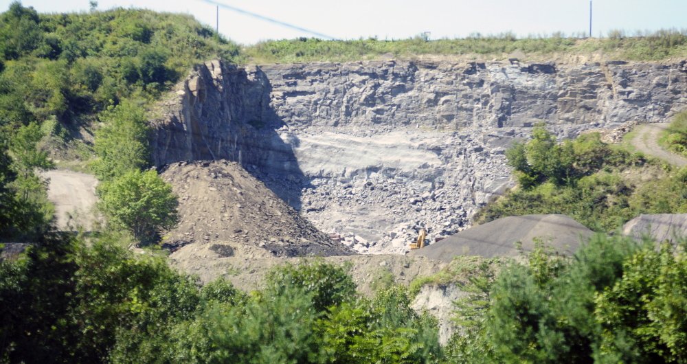 The McGee rock blasting pit is seen from east side of Kennebec River on Sept. 4, 2015, in Augusta. Planning Board members have delayed action on a license for the pit so they have time to consult an expert and experience the blasting for themselves.