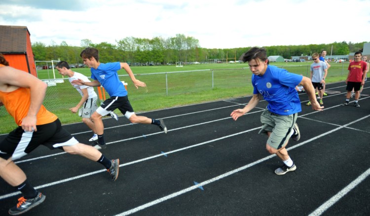 Winslow High School track athletes Jake Warn, left center, and Spencer Miranda sprint on the school's track Wednesday.
