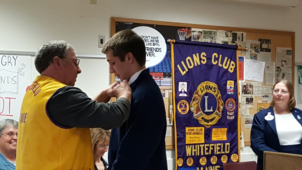 Whitefield Lions Club Director Barry Tibbetts, left, pins Erskine Academy Leo Club President Harrison Mosher as District Governor Michelle Crocker looks on. The formal induction ceremony was held for Leo Club members on May 3 at Erskine Academy in South China.