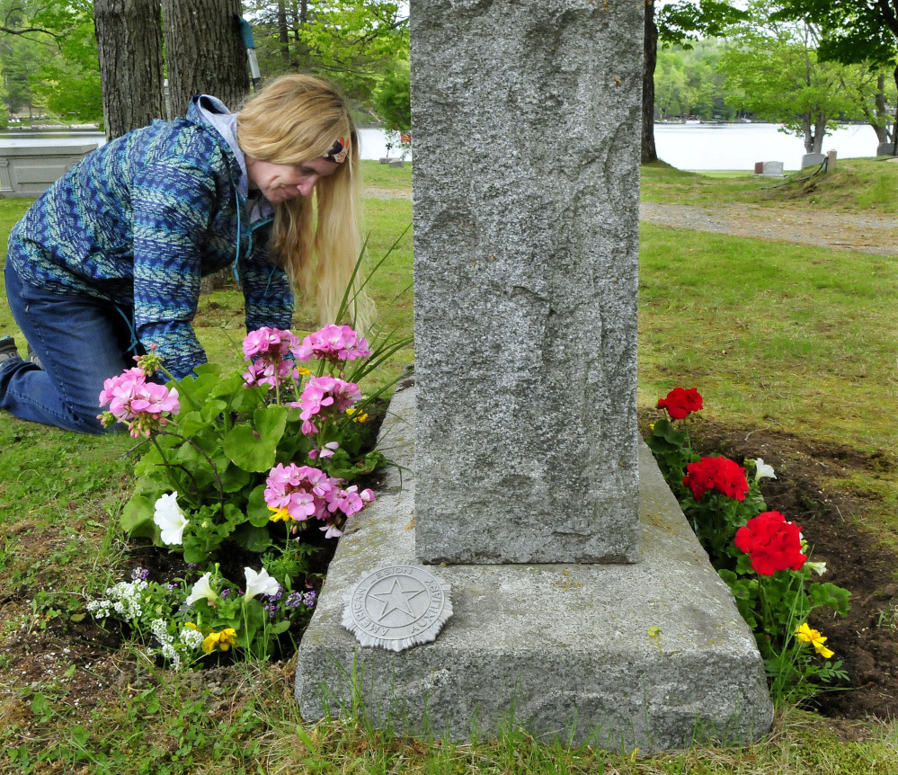 Sara Rushton plants flowers Thursday on both sides of the grave of her grandmother at the Lakeview Cemetery in Oakland for Memorial Day.