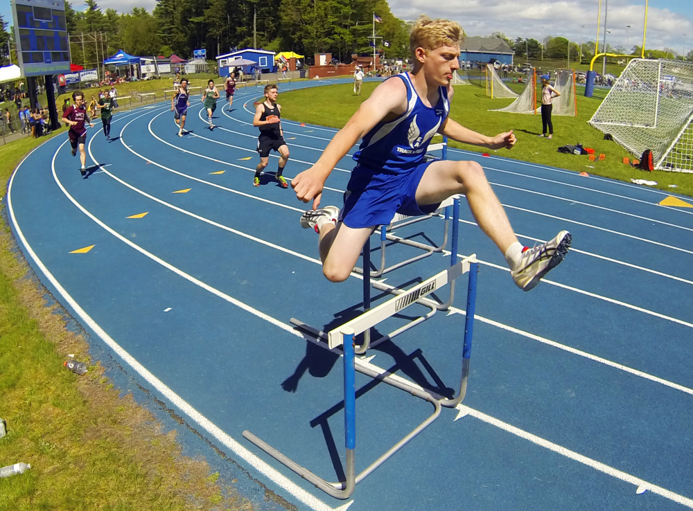 Erskine's Elliot Stinchfield runs the 300 meter hurdles at the Kennebec Valley Athletic Conference track and field championships Saturday at McMann Field in Bath.