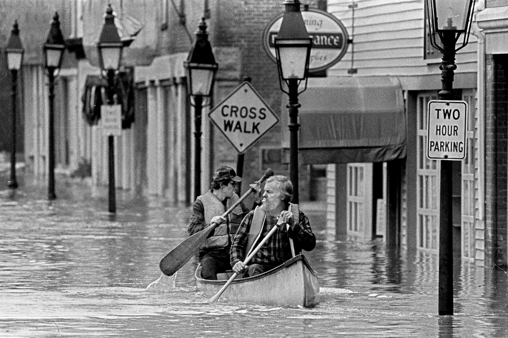 This April 1987 file photo Sumner "Sam" Webber, left, and John Jacques paddling a canoe on Water Street just past Central Street after the Kennebec River flooded downtown Hallowell.