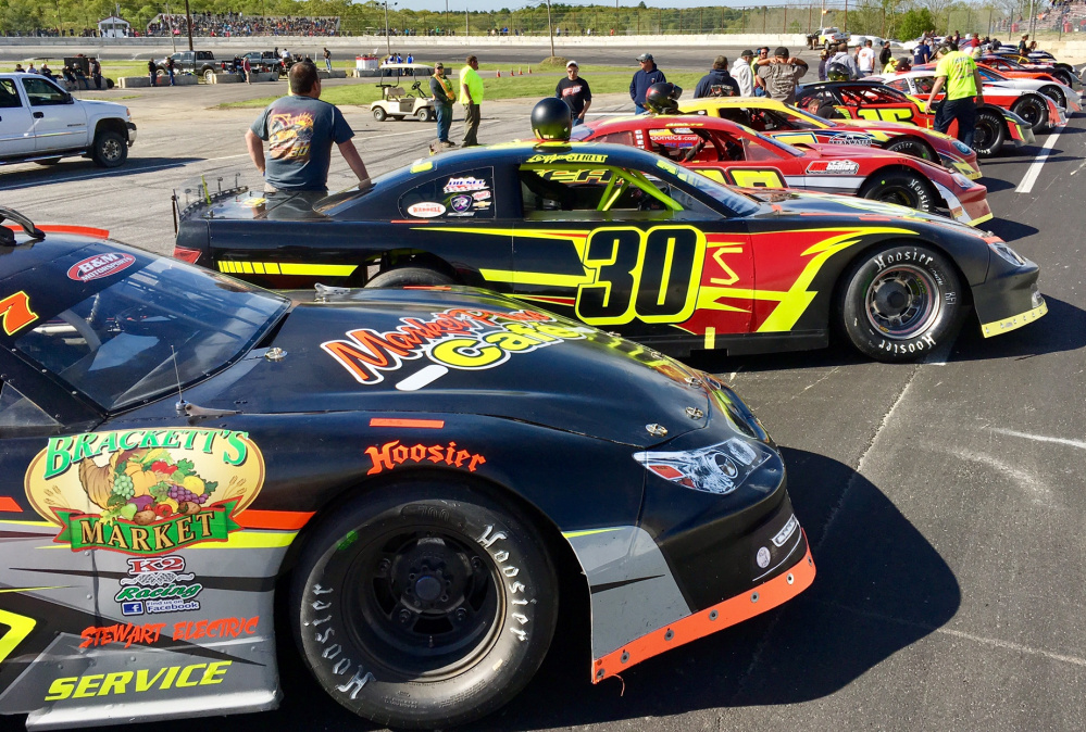 Staff photo by Travis Barrett 
 Cars line up on the frontstretch for driver introductions before the start of the Coastal 200 on Sunday at Wiscasset Speedway.