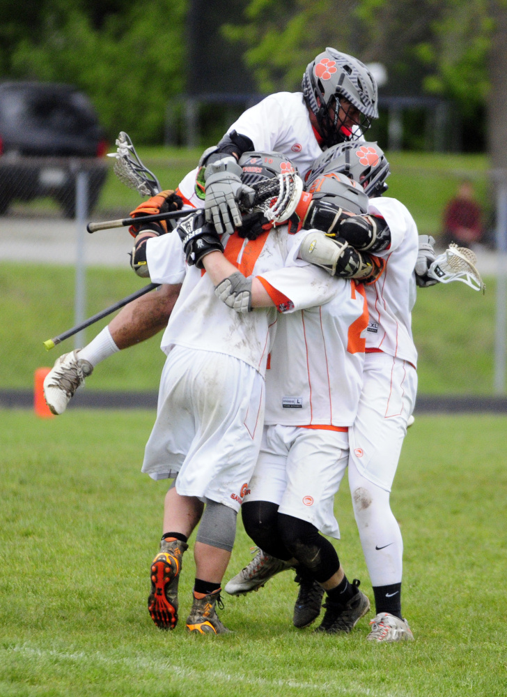 Members of the Gardiner boys lacrosse team celebrate an overtime victory Tuesday over Messalonskee at Hoch Field in Gardiner.